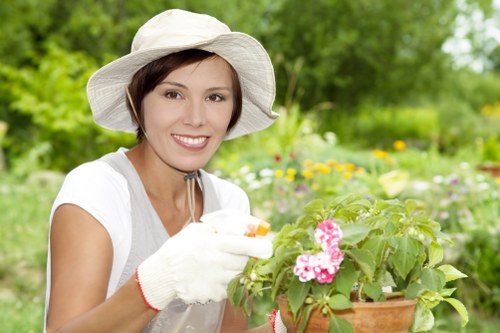 Worker wearing protective gear using a powered gardening tool